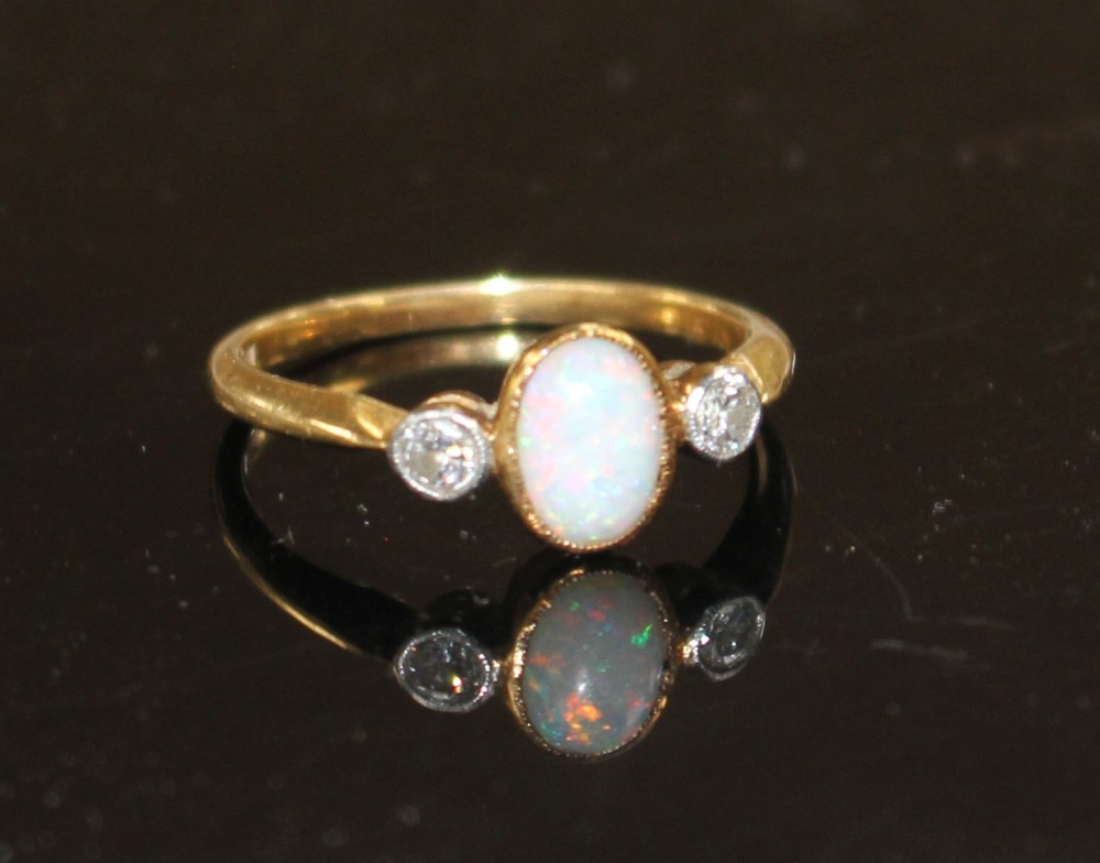 A mid 20th century 18ct and Pt, white opal and diamond three stone ring, size O/P, gross weight 2.8 grams.